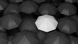 Classic large black umbrellas tops with one white standing out
