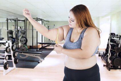 Woman measure her arm in the gym room